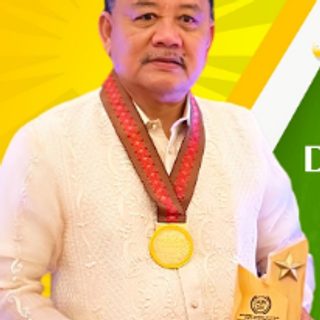 Dr. Maximo C. Aljibe, CHED honoree, in a barong holding a trophy